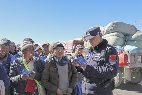 圖為里孜出入境邊防檢查站移民管理警察查驗首批通關的尼泊爾旅客證件。(中新社發 郭遠敬 攝)