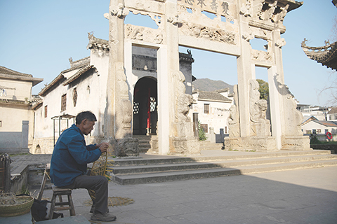 ◎ 二零二五年三月廿五日,當地居民在安徽省黃山市歙縣的高陽廊橋前製作竹藝品。