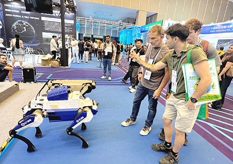 境外採購商在廣交會上觀看中國企業展出的機器狗。(中新社記者 程景偉 攝)