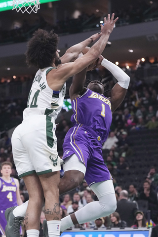 ◎ 十一月十五日,在密爾沃基舉行的一場NBA常規賽的下半場,洛杉磯湖人隊的阿杜.蒂羅遭密爾沃基公鹿隊的小安德烈.積遜犯規性攔截。(美聯社/莫里.加什)