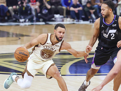 ◎ 十一月二十四日,勇士隊居里(左)帶球突破。金州勇士隊主場一三四比一一七戰勝猶他爵士隊。(新華社發 董旭東 攝)