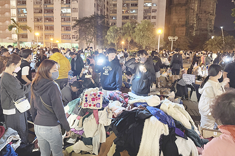 ◎ 十一月廿七日晚,志願者在香港大埔宏福苑附近的社區廣場分揀、派發捐贈衣物。(羅英傑 攝)