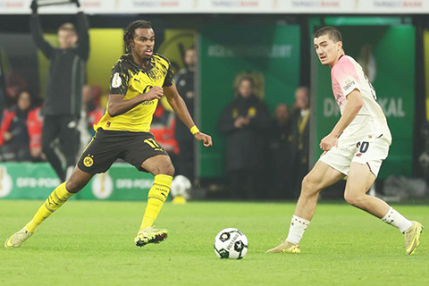 ◎ 十二月二日,利華古遜隊馬沙(右)與多蒙特隊卓禾美卡拼搶。德國杯足球賽十六強賽中,利華古遜隊客場一比0戰勝多蒙特隊。(新華社發)