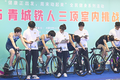 ◎ 十二月六日,內蒙古呼和浩特市,選手參加鐵人三項中的自行車比賽。青城鐵人三項室內挑戰賽啟幕,近三百名選手在游泳、自行車、跑步項目上展開角逐。(中新社記者劉文華 攝)