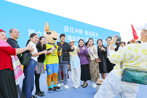 ◎ 一月十二日,第六屆亞洲沙灘運動會倒計時一百天誓師大會在海南省三亞市舉行。圖為民眾與三亞亞沙會吉祥物「亞亞」合影。(中新社記者 駱雲飛 攝)