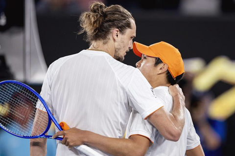 ◎ 1月27日,施維列夫(左)和錢亮拿賽後擁抱致意。澳大利亞網球公開賽男單四分之一決賽中,德國選手施維列夫3比1戰勝美國選手錢亮拿,晉級四強。(新華社發 胡涇辰 攝)