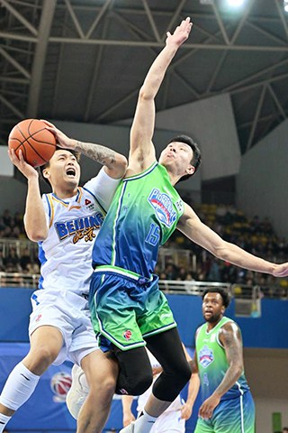 ◎ 1月28日,天津先行者隊球員鄭昊燃(中)防守北京北汽隊球員趙睿。CBA常規賽第21輪比賽中,天津先行者隊主場93比78戰勝北京北汽隊。(新華社記者趙子碩攝)