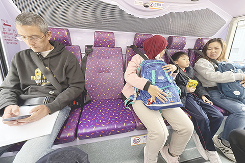 ◎ 香港近日開始實施安全帶新規,大部份市民自覺遵守,外籍人士亦了解有關規定,巴士上見到不少市民與外籍人士主動繫安全帶。(香港中通社記者張明臻 攝)