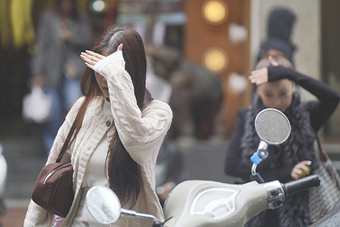 ◎ 一月卅一日,香港天氣大致多雲。初時有一兩陣雨及能見度較低,昨晚轉涼,吹和緩至清勁偏北風。展望今日及星期一巿區最低氣溫約攝氏十四、十五度,新界再低幾度,部份時間有陽光。本周中期氣溫回升,但早上仍然清涼。圖為出行的市民抬手遮擋雨水。(香港中通社記者陳奕啟 攝)