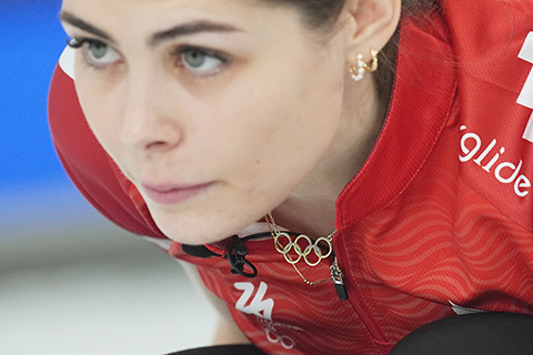 ◎ 2月13日,冬奧會冰壺女子循環賽繼續在科爾蒂納奧林匹克冰壺館進行。圖為丹麥女子冰壺選手賈斯敏.霍爾特曼(Jasmin HOLTERMANN)佩戴著金色五環項鏈參加比賽。(中新社記者崔楠 攝)