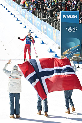 ◎ 2月15日,挪威隊選手克萊博(上)衝線。冬奧會越野滑雪男子4X7.5公里接力比賽中,挪威隊奪得冠軍,法國隊和意大利隊分別獲得亞軍和季軍。(新華社記者 賀燦鈴 攝)