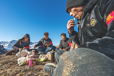 ◎ 二月六日,在西藏山南市隆子縣玉麥鄉境內,護邊員們在巡邏途中吃午飯。他們圍坐在一片平坦草地,從揹包里掏出糌粑、卡塞(一種傳統油炸面食),再喝幾口酥油茶,這就是巡邏護邊途中一頓簡單的午餐。