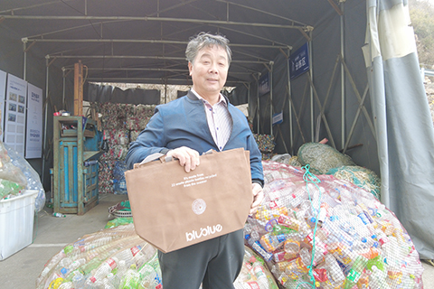 郭文標展示由再生海洋塑料粒子製作的單肩包。(傅飛揚 攝)