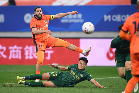 ◎ 三月二十日,青島海牛隊球員梅薩烏迪(左一)與浙江俱樂部綠城隊球員徐俊馳拼搶。浙江俱樂部綠城隊客場四比一戰勝青島海牛隊。(新華社記者 李紫恆 攝)