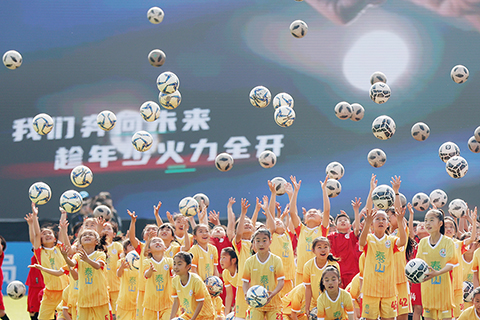◎ 四月二日,「省長杯」江蘇省青少年校園足球聯賽在南京開賽,為全省青少年搭建展示自我、追逐夢想的平台,推動校園足球的普及與發展。圖為參加開幕式表演的青少年將足球拋向空中。(中新社記者 泱波 攝)