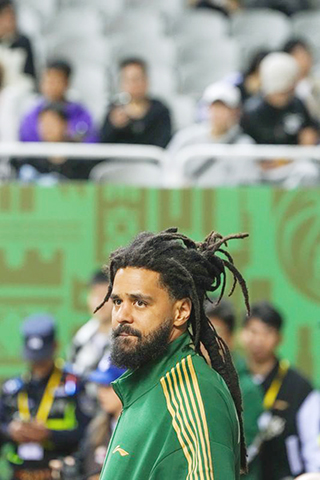 ◎ 四月八日,跨界加盟南京同曦俱樂部的美國說唱歌手傑曼·拉馬爾·科爾在場邊觀賽。CBA常規賽第三十六輪比賽中,南京天之藍隊主場一百零一比九十二戰勝北京控股隊。(新華社記者 李博 攝)