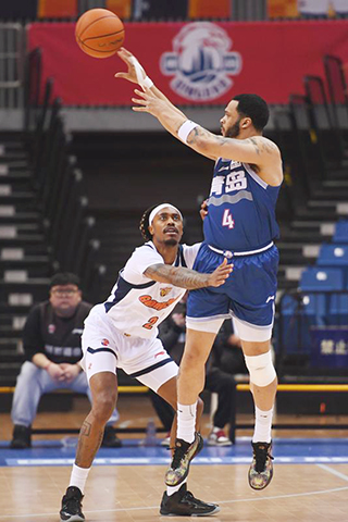 ◎ 四月八日,青島嶗山啤酒隊球員韋瑟斯龐(右)傳球。CBA常規賽第三十六輪比賽中,青島嶗山啤酒隊主場一百零五比一百一十不敵廣東東陽光隊。(新華社記者 李紫恆 攝)