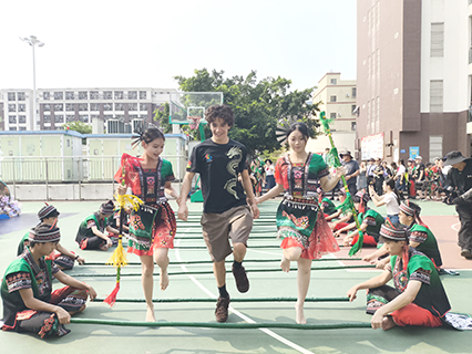 海口山高高級實驗中學的校園裡,美國和海南的青少年一起跳竹竿舞。(中新社)