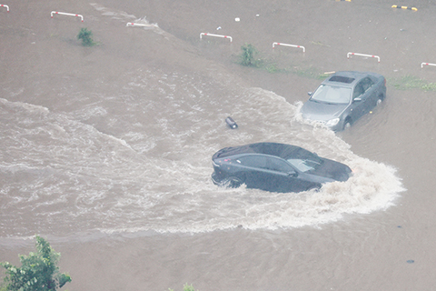 ◎ 七月十三日,受降雨影響,遼寧省瀋陽市區部份街道路面積水,汽車在水中行駛。當日九時十分,遼寧省瀋陽市防汛抗旱指揮部發佈全市防汛紅色預警,提升全市防汛應急響應級別至一級。(中新社記者 于海洋 攝)